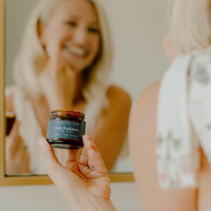 Person holding a jar of cream in front of a mirror